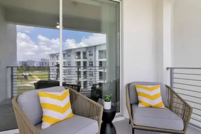 two chairs sitting on a balcony with a view of a building at Modern Storey Lake Resort Disney Orlando 3150-303 in Kissimmee