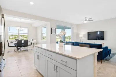 a kitchen and living room with a blue couch at Modern Storey Lake Resort Disney Orlando 3171-206 in Kissimmee