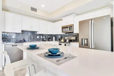 a kitchen with white cabinets and blue bowls on a counter at Modern Storey Lake Resort Disney Orlando 3171-107 in Kissimmee