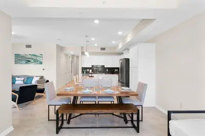 a dining room and living room with a table and chairs at Modern Boho Storey Lake Resort Disney 3150-106 in Kissimmee