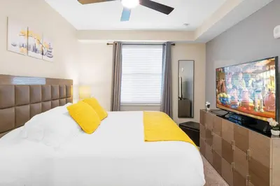 a bedroom with a white bed and a flat screen tv at Modern Storey Lake Resort Disney Orlando 4751-306 in Kissimmee
