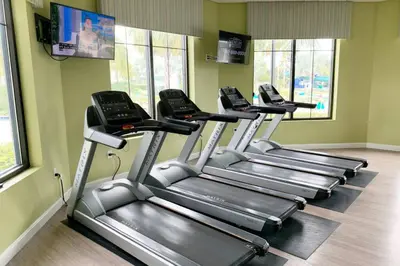 a row of treadmills in a gym with windows at Modern Storey Lake Resort Disney Orlando 3121-402 in Kissimmee