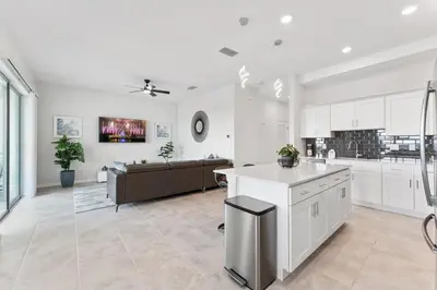 a kitchen and living room with white cabinets and a couch at Modern Storey Lake Resort Disney Orlando 3161-405 in Kissimmee