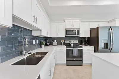 a kitchen with white cabinets and a sink at Modern Storey Lake Resort Disney Orlando 3161-405 in Kissimmee