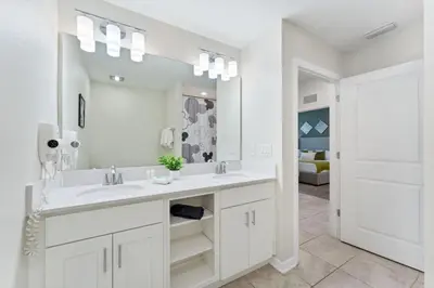a white bathroom with a sink and a mirror at Modern Storey Lake Resort Disney Orlando 3141-103 in Kissimmee