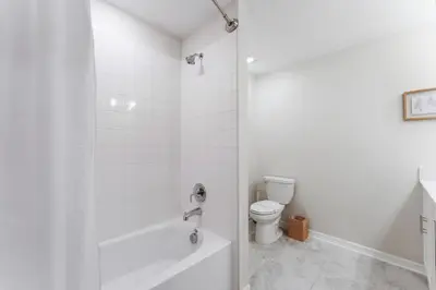 a white bathroom with a tub and a toilet at Brand New Lakeview Storey Lake Resort Disney 3121-103 in Kissimmee