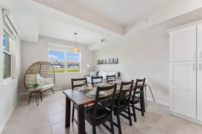 a dining room and living room with a table and chairs at Brand New Lakeview Storey Lake Resort Disney 3121-103 in Kissimmee