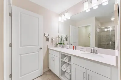 a white bathroom with a sink and a mirror at Modern Storey Lake Resort Disney Orlando 3171-302 in Kissimmee