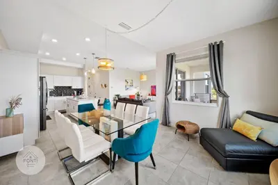 a kitchen and living room with a glass table and chairs at Modern Storey Lake Resort Disney Orlando 3161-402 in Kissimmee