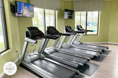 a row of three treadmills in a gym at Modern Boho Storey Lake Resort Disney 3180-207 in Kissimmee