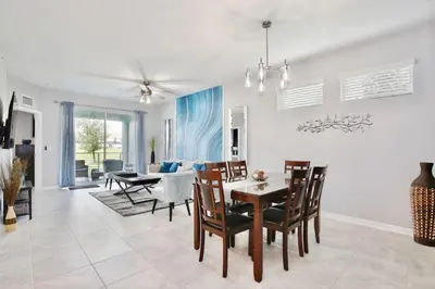 a dining room and living room with a table and chairs at Modern Storey Lake Resort Disney Orlando 3121-108 in Kissimmee