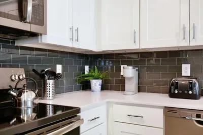a kitchen counter with white cabinets and a sink at Modern Storey Lake Resort Disney Orlando 3121-108 in Kissimmee