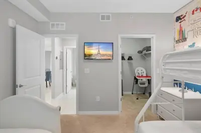 a white bedroom with a bunk bed and a bedroom with a bunk bed at Modern Storey Lake Resort Disney Orlando 4741-104 in Kissimmee