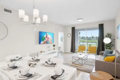 a white living room with a table and a couch at Modern Storey Lake Resort Disney Orlando 3141-105 in Kissimmee
