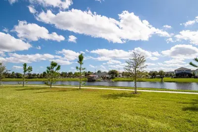 a park with a body of water and palm trees at Modern Storey Lake Resort Disney Orlando 3141-105 in Kissimmee