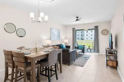 a dining room and living room with a table and chairs at Modern Storey Lake Resort Disney Orlando 3180-104 in Kissimmee