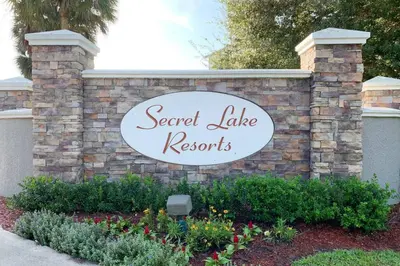 a sign for a secret lake records sign on a brick wall at Secret Lake Resort 3BR Apt Disney Orlando 3175-205 in Kissimmee