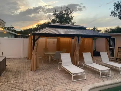a patio with a gazebo with chairs and a table at Botanical Tranquility in Orlando