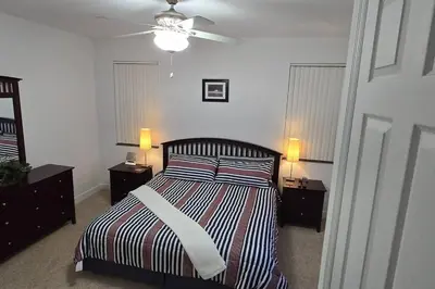 a bedroom with a bed with two night stands and two lamps at Smart home near Disney world, Silver Spurs Arena in Kissimmee