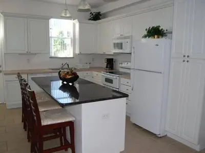 a kitchen with white cabinets and a black counter top at Smart home near Disney world, Silver Spurs Arena in Kissimmee