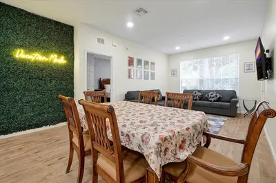 a dining room with a table and chairs and a couch at Windsor Hills Spacious Condo,Pool,Slides,By Disney in Orlando
