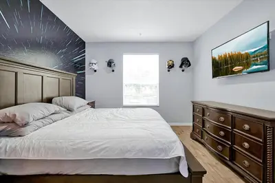 a bedroom with a large bed and a dresser at Windsor Hills Spacious Condo,Pool,Slides,By Disney in Orlando