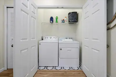 a small white laundry room with a washer and dryer at Windsor Hills Spacious Condo,Pool,Slides,By Disney in Orlando
