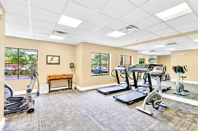 a fitness room with treadmills and elliptical machines at Modern 1BR-King Bed with Pool & Hot Tub-Near Disney in Orlando