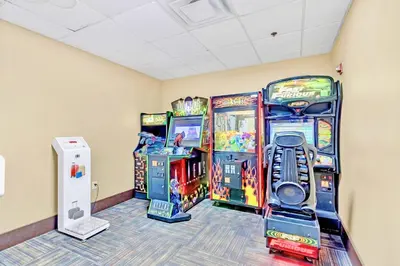 a room with three arcade games and a wii at Modern 1BR-King Bed with Pool & Hot Tub-Near Disney in Orlando