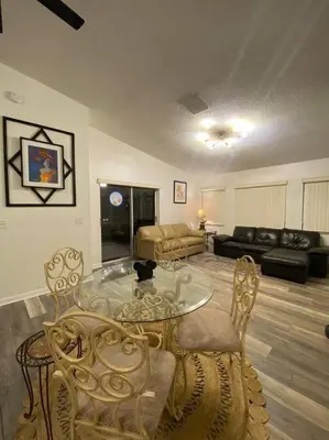 a living room with a glass table and chairs at Casa a 3 millas de Disney in Kissimmee