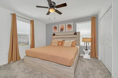a bedroom with a bed and a ceiling fan at Perfect 9 Bed 5 Bath Home/Games room/ Private pool in Kissimmee