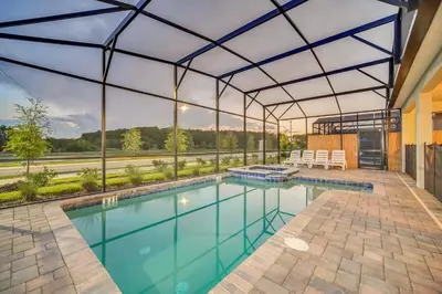 an indoor swimming pool in a building with a glass ceiling at Perfect 9 Bed 5 Bath Home/Games room/ Private pool in Kissimmee