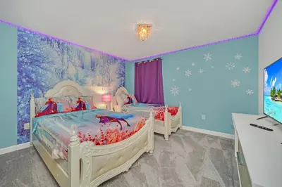 two twin beds in a room with a tv at Perfect 9 Bed 5 Bath Home/Games room/ Private pool in Kissimmee
