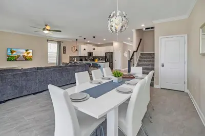 a dining room and living room with a white table and chairs at AVH-2746-SL in Kissimmee