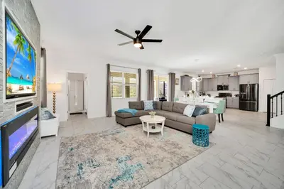 a living room with a couch and a flat screen tv at Brand New 6BD, Gameroom / Movie Theater And Pool in Kissimmee