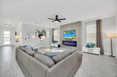 a living room with a couch and a tv at Brand New 6BD, Gameroom / Movie Theater And Pool in Kissimmee