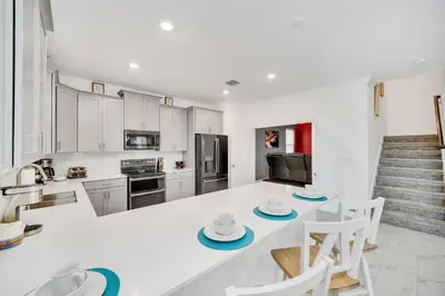 a kitchen with white cabinets and a white counter top at Brand New 6BD, Gameroom / Movie Theater And Pool in Kissimmee