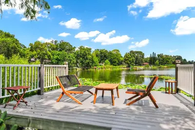 a wooden deck with two chairs and a table and chairs at Spring Lake King Balcony Suite in Orlando