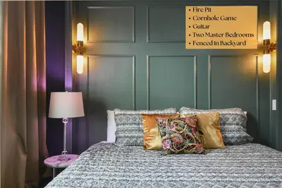 a bedroom with a bed with pillows and a lamp at 2 King En Suite Fenced Yard Pet Friendly in Orlando