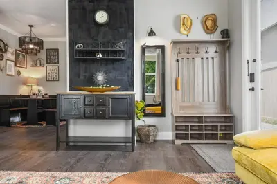 a living room with a desk and a clock on the wall at 2 King En Suite Fenced Yard Pet Friendly in Orlando