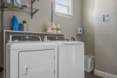 a washing machine in a room with a refrigerator at 2 King En Suite Fenced Yard Pet Friendly in Orlando