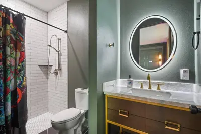 a bathroom with a toilet and a sink and a mirror at 2 King En Suite Fenced Yard Pet Friendly in Orlando