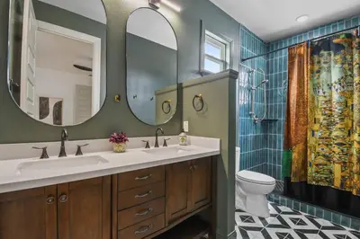 a bathroom with two sinks and a toilet and a mirror at Pool Table, BBQ, Walking Distance to Local Gems in Orlando