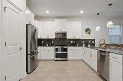 a kitchen with white cabinets and stainless steel appliances at Welcome to the Ultimate Vacation Wonderland in Kissimmee