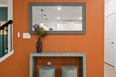 a mirror on a wall with a table and stools at Welcome to the Ultimate Vacation Wonderland in Kissimmee