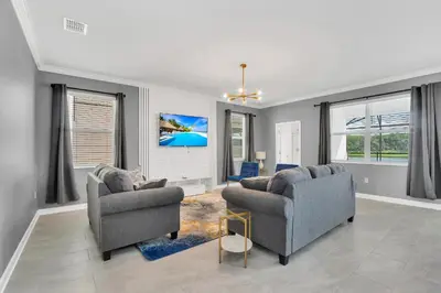 a living room with two couches and a tv at Mickey's Retreat /Pool With Water Slide/ Game Room in Kissimmee