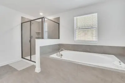 a white bathroom with a tub and a shower at Mickey's Retreat /Pool With Water Slide/ Game Room in Kissimmee