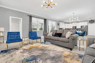 a living room with a couch and two blue chairs at Mickey's Retreat /Pool With Water Slide/ Game Room in Kissimmee
