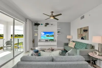 a living room with a couch and a tv at Stylish 2-Bed Condo With Resort Amenities/Patio in Kissimmee