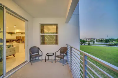 a balcony with two chairs and a table on it at Stylish 2-Bed Condo With Resort Amenities/Patio in Kissimmee